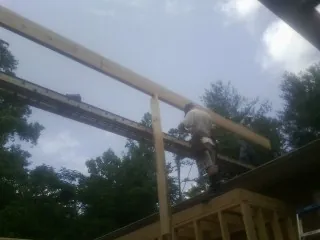 Carpenter setting a ridge beam over a new addition frame — Ice Dam Removal by Roofing Brothers in Torrington