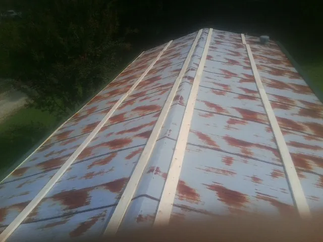 Rusted metal roof panels with new wood purlins before replacement — Storm Damage Roof Repair in Torrington by Roofing Brothers